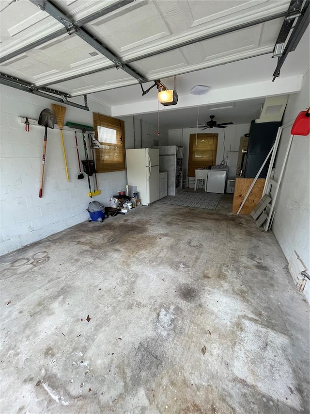 garage with a garage door opener and white fridge