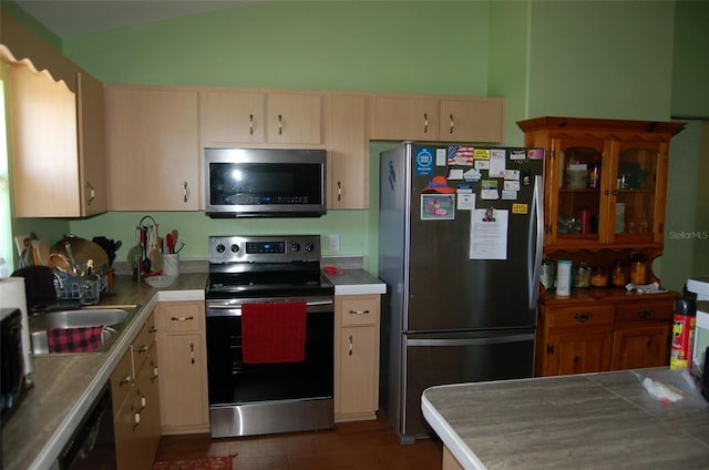 kitchen with light brown cabinets, lofted ceiling, stainless steel appliances, and sink