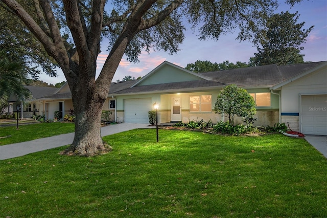 ranch-style house featuring a yard and a garage