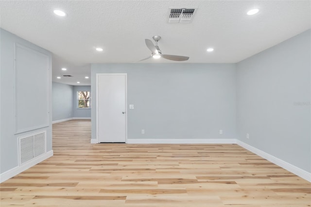 empty room with light hardwood / wood-style floors, a textured ceiling, and ceiling fan