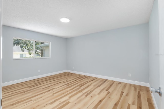 empty room featuring light hardwood / wood-style floors and a textured ceiling