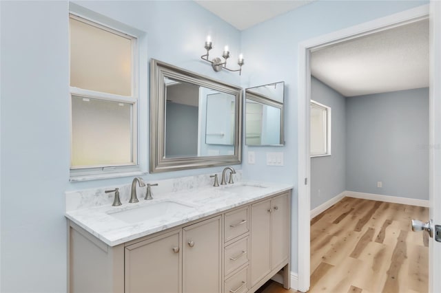 bathroom featuring wood-type flooring, vanity, and a textured ceiling