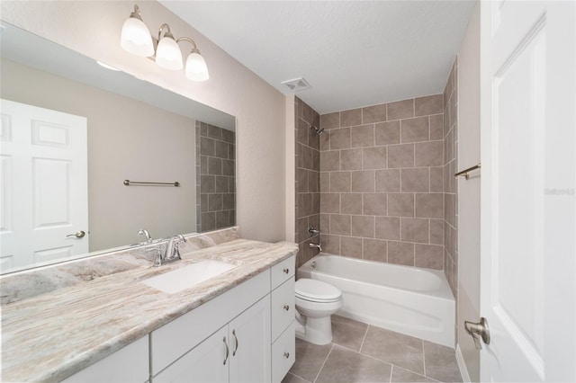 full bathroom with toilet, tiled shower / bath combo, tile patterned floors, a textured ceiling, and vanity