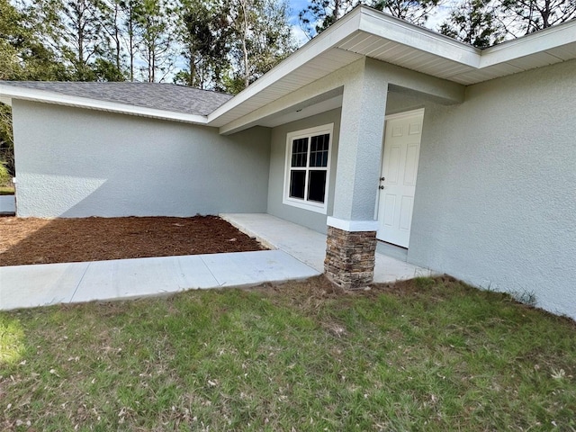 property entrance with a lawn