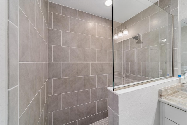 bathroom with vanity and a tile shower