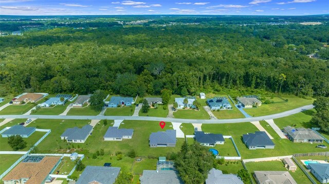 birds eye view of property featuring a residential view and a wooded view
