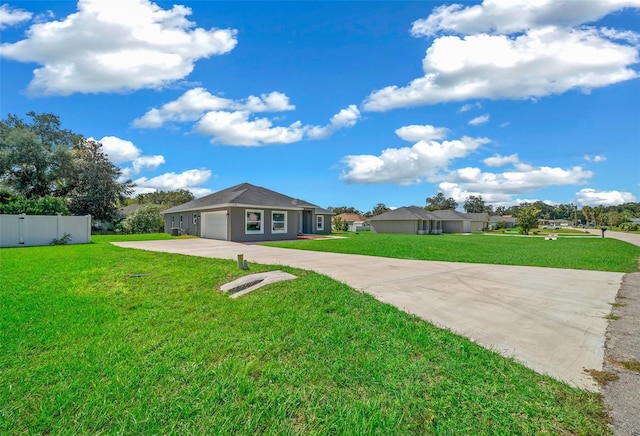 view of front facade featuring an attached garage, a front lawn, fence, and concrete driveway
