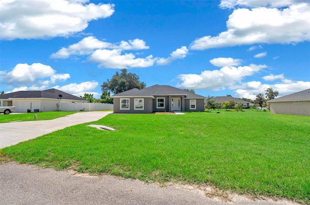 ranch-style house with stucco siding, a front lawn, driveway, and fence