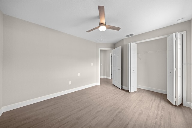 unfurnished bedroom featuring a closet, light wood-type flooring, and ceiling fan