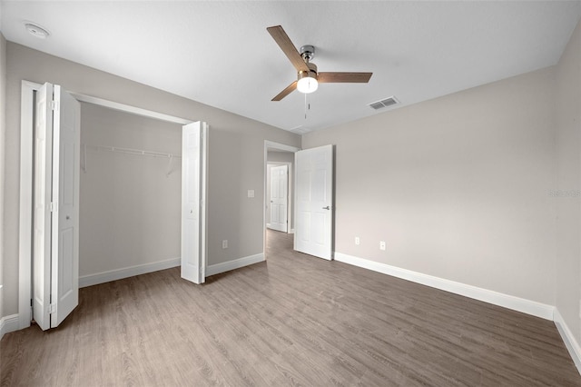 unfurnished bedroom featuring a closet, ceiling fan, and light wood-type flooring