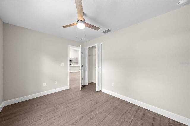 unfurnished bedroom with hardwood / wood-style flooring, a closet, and ceiling fan