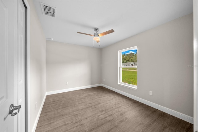 spare room with wood finished floors, visible vents, baseboards, and ceiling fan