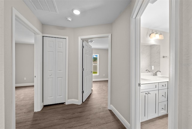 hall with baseboards, dark wood-style flooring, and visible vents