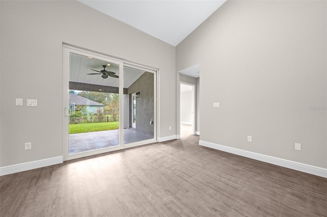 empty room featuring lofted ceiling, a ceiling fan, wood finished floors, and baseboards