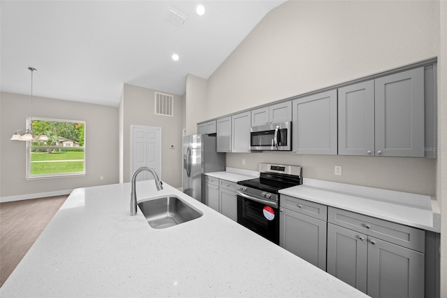 kitchen with stainless steel appliances, visible vents, gray cabinets, a sink, and high vaulted ceiling