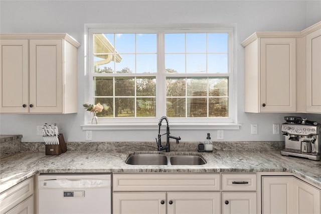 kitchen with sink, a healthy amount of sunlight, dishwasher, and light stone counters