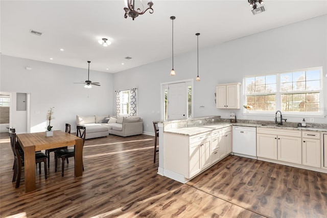 kitchen with white dishwasher, sink, kitchen peninsula, dark hardwood / wood-style flooring, and light stone counters