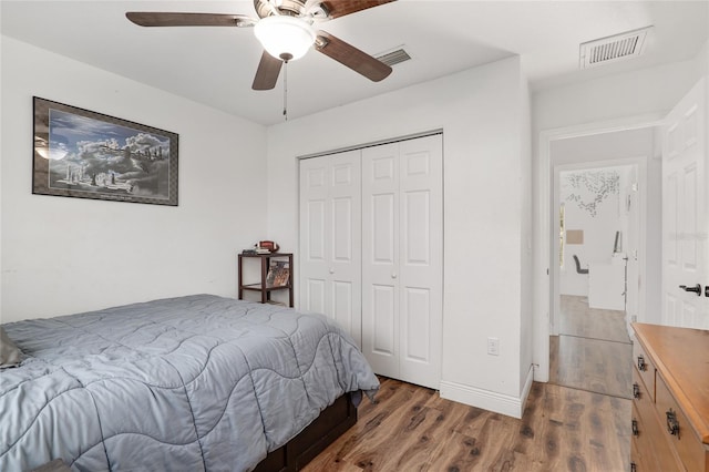 bedroom featuring dark wood-type flooring, a closet, and ceiling fan