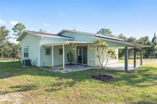 rear view of house featuring a patio, a lawn, and central air condition unit