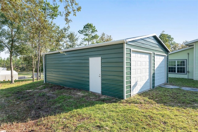 view of outbuilding with a garage and a lawn