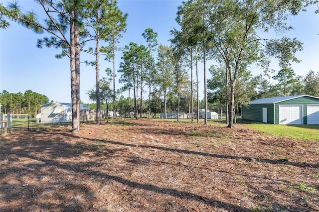 view of yard with a garage and an outbuilding