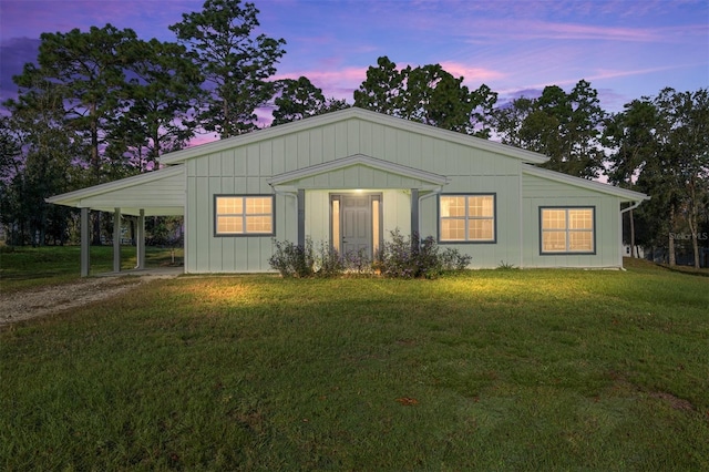 view of front of home with a carport and a yard