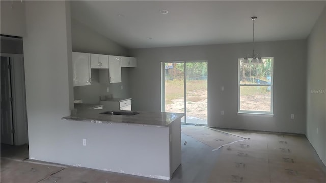 kitchen featuring white cabinetry, plenty of natural light, pendant lighting, and vaulted ceiling