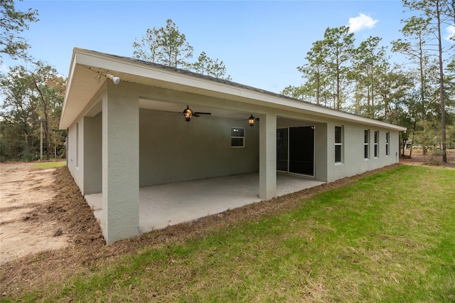 rear view of property featuring a yard, a patio area, and ceiling fan