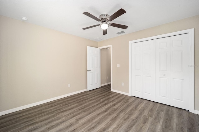 unfurnished bedroom featuring a closet, ceiling fan, and dark hardwood / wood-style flooring