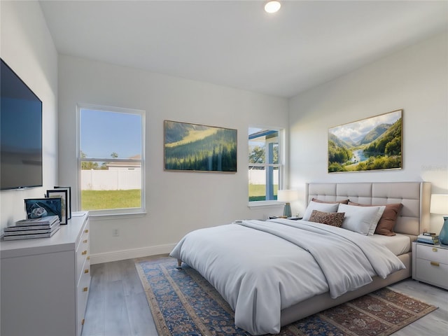 bedroom featuring multiple windows and light hardwood / wood-style floors