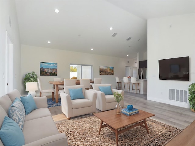 living room with light hardwood / wood-style floors and high vaulted ceiling