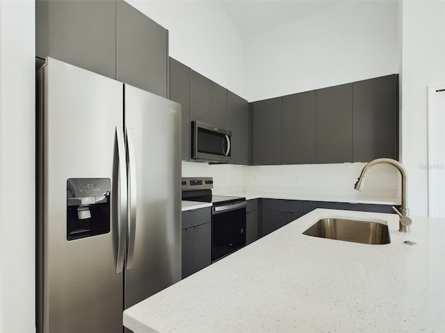 kitchen featuring appliances with stainless steel finishes, light stone countertops, and sink