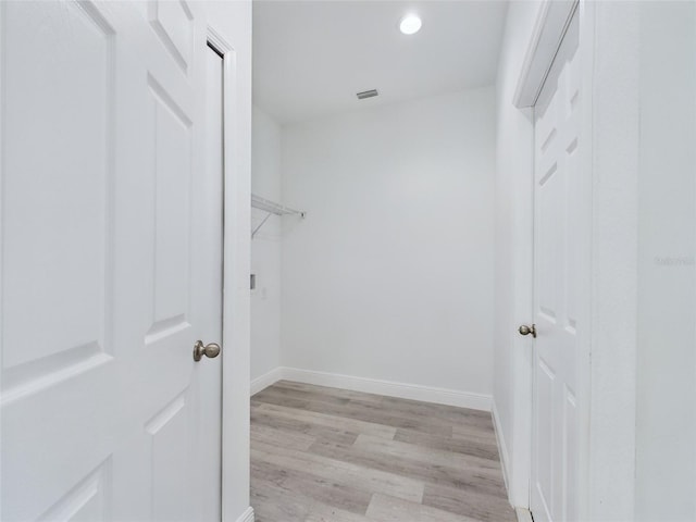 walk in closet with light hardwood / wood-style flooring