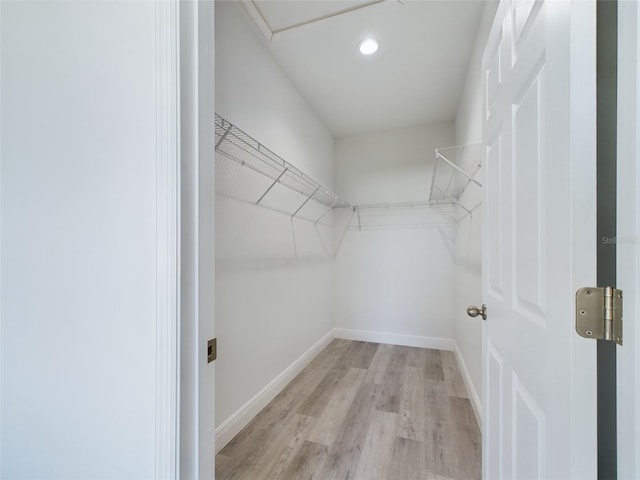 walk in closet with light hardwood / wood-style floors