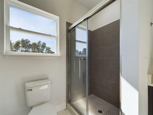 bathroom with a shower with door and toilet