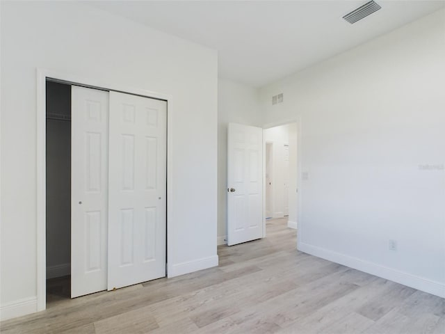 unfurnished bedroom featuring light hardwood / wood-style floors and a closet