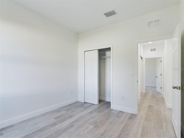 unfurnished bedroom featuring light hardwood / wood-style floors and a closet