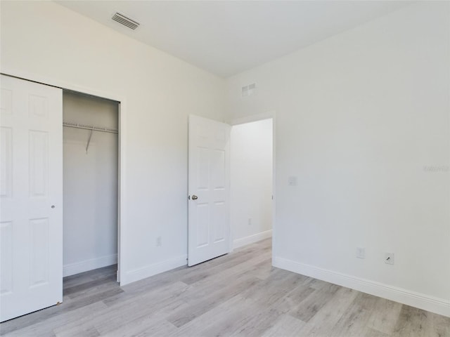 unfurnished bedroom featuring light hardwood / wood-style floors and a closet