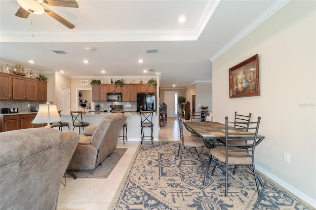 tiled dining room with ceiling fan and ornamental molding