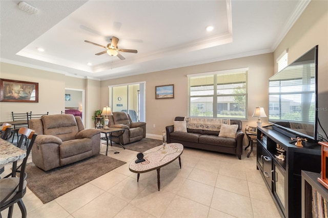 living room with crown molding, light tile patterned flooring, a tray ceiling, and ceiling fan