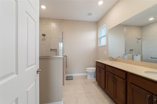 bathroom with vanity, toilet, and tiled shower