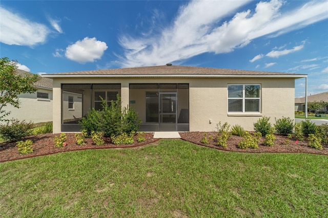 rear view of property with a yard and a sunroom