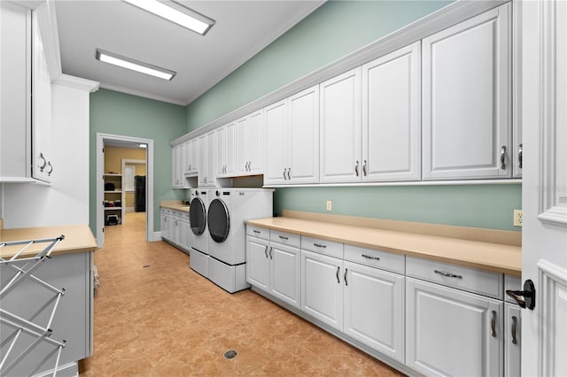 laundry room with washer and dryer, cabinets, and ornamental molding