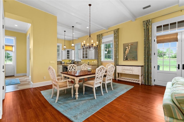 dining area with beam ceiling, a healthy amount of sunlight, dark wood-type flooring, and an inviting chandelier