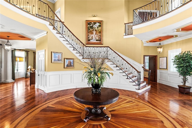 foyer entrance with ornamental molding and a high ceiling