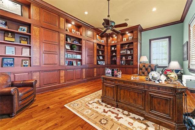 office with built in shelves, light wood-type flooring, ceiling fan, and crown molding