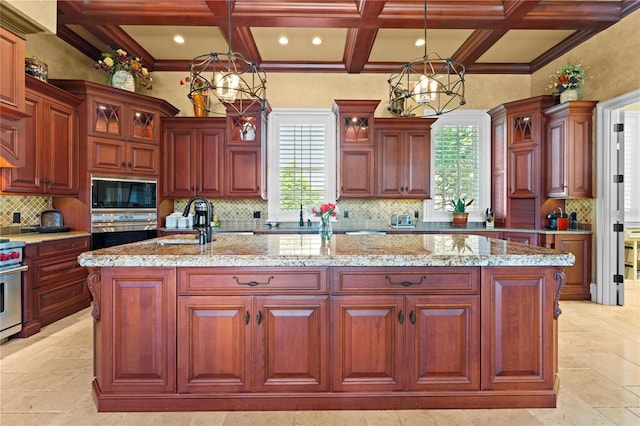 kitchen featuring hanging light fixtures, stainless steel appliances, a kitchen island with sink, and coffered ceiling