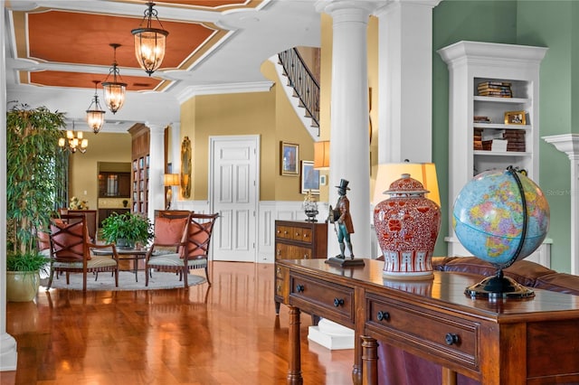 interior space with a wainscoted wall, decorative columns, a chandelier, and wood finished floors