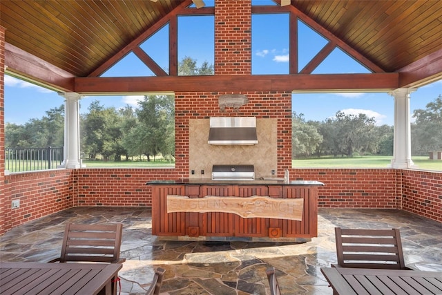 sunroom / solarium with lofted ceiling, wooden ceiling, and a sink