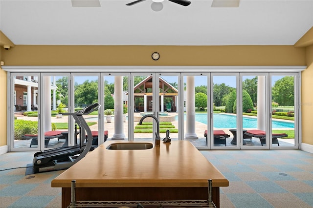 kitchen featuring carpet floors, baseboards, and a sink